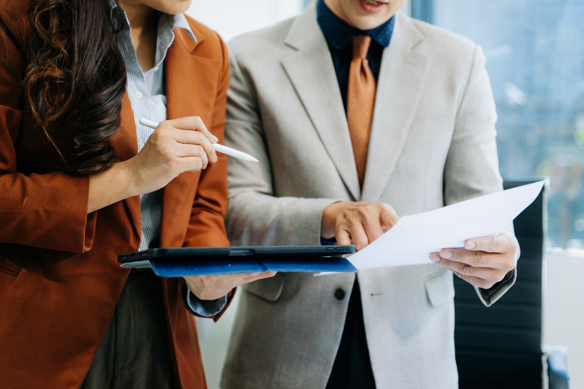 Business professionals reviewing documents and a tablet together
