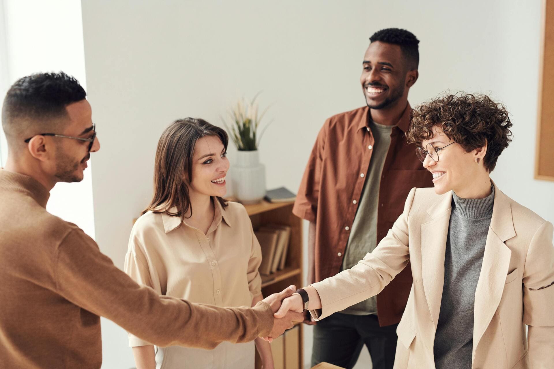 Group of colleagues shaking hands and smiling during a meeting