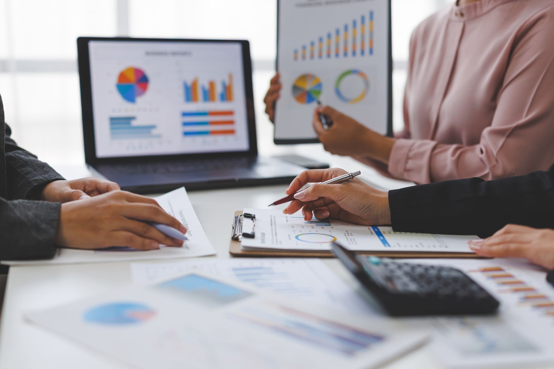 People reviewing financial charts and graphs in a meeting