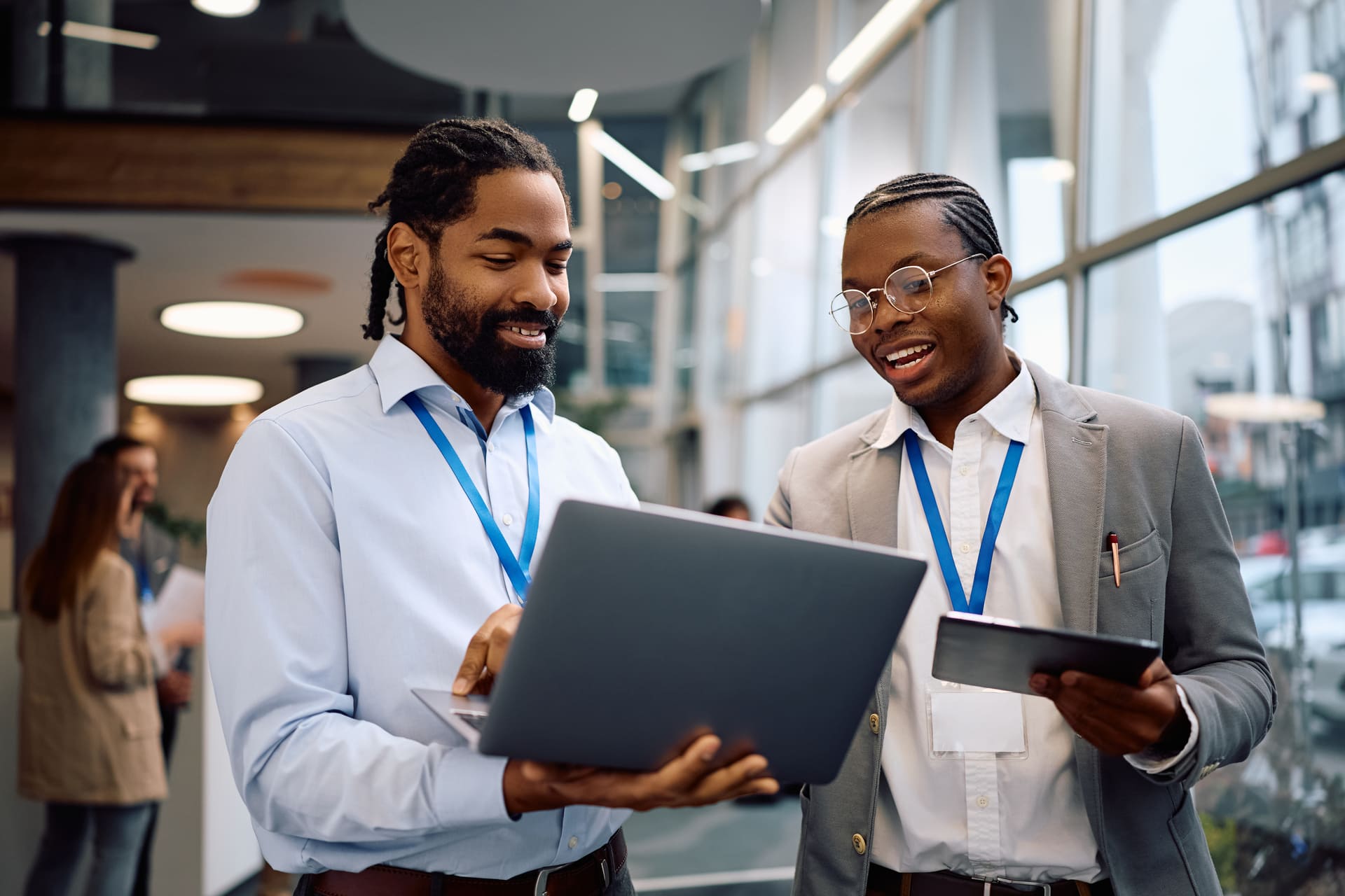 Two business professionals looking at a laptop and smiling in an office.