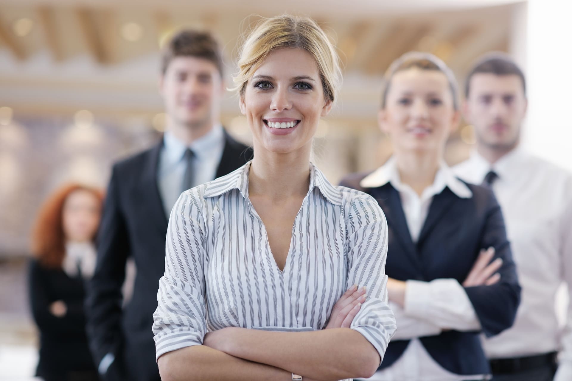 business-woman-standing-with-her-staff-in-backgroud
