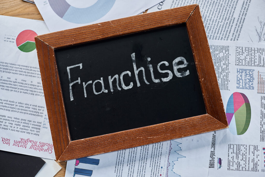 franchise-concept-on-chalkboard-surrounded-by-business documents