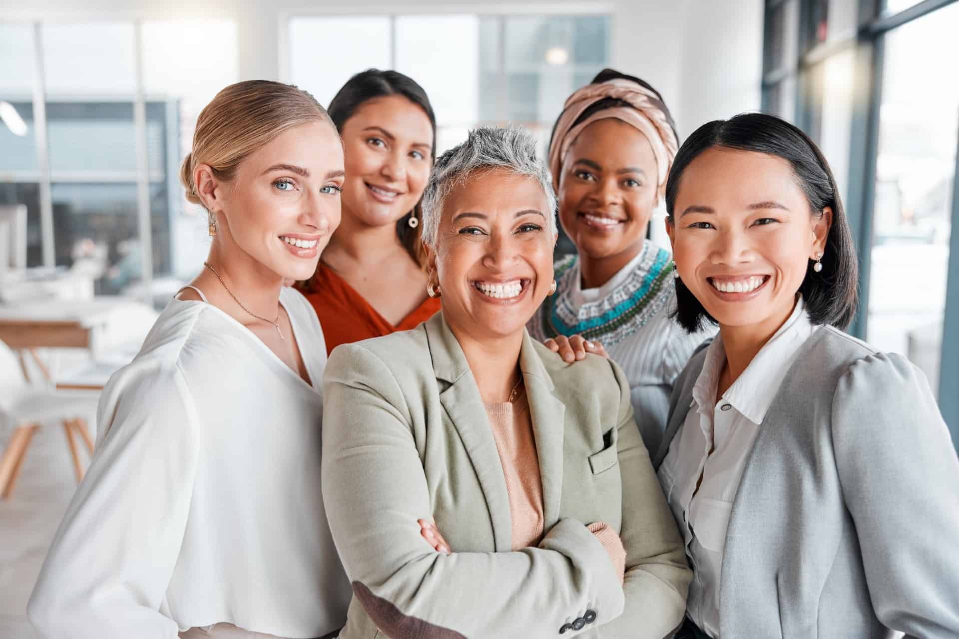 Group-of-professional-women-smiling-together-in-modern-office