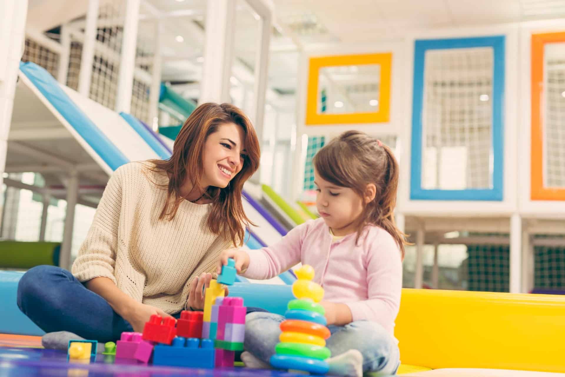 Woman-and-child-playing-with-colorful-building-blocks-indoors