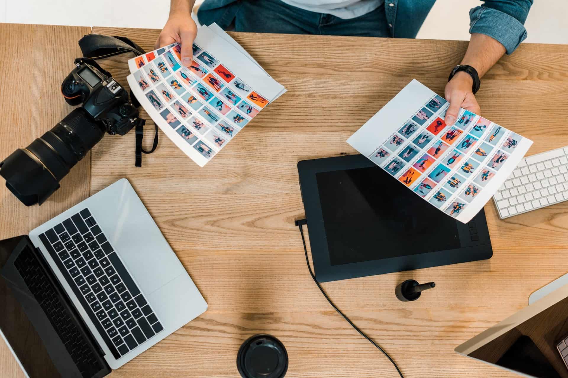 Photographer reviewing printed images at a creative workstation