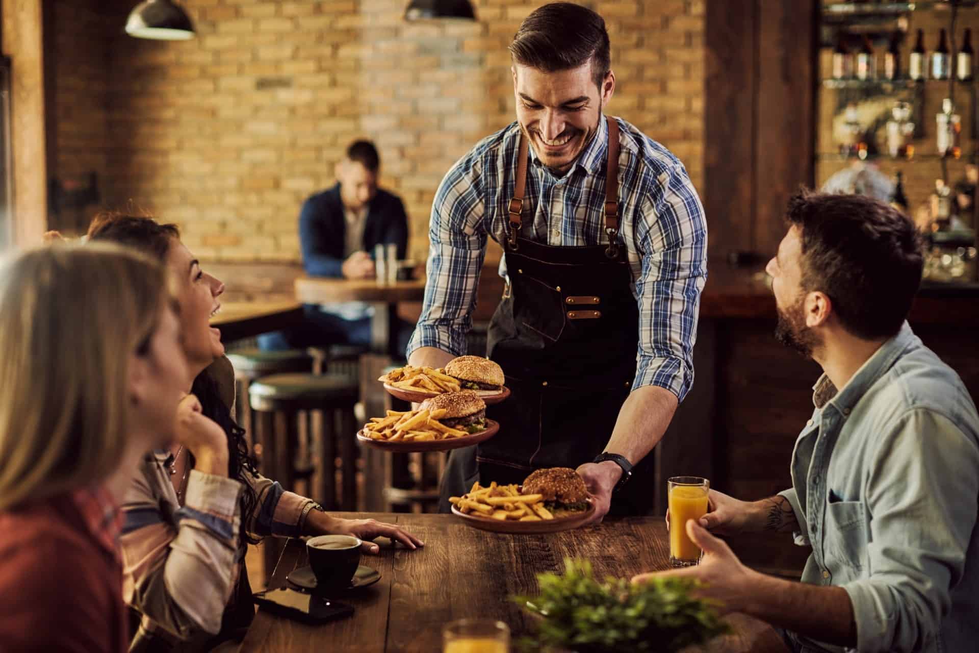 Restaurant server delivering burgers and fries to customers
